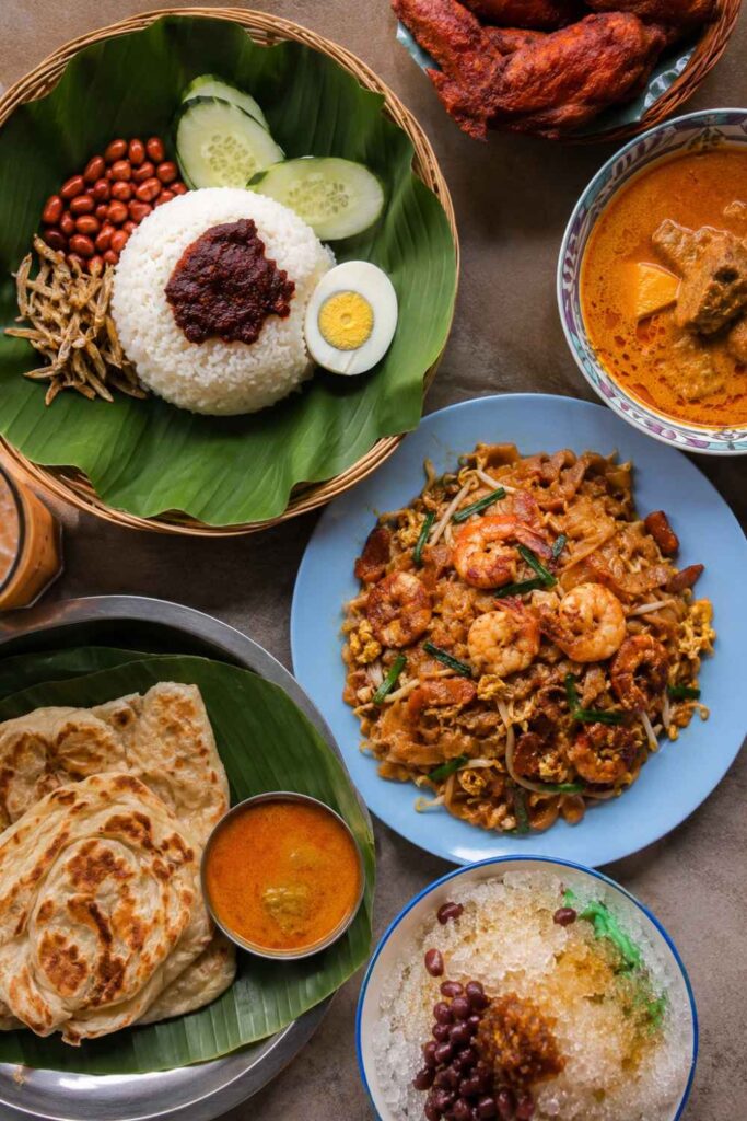 Best Things to Do in Malaysia for First-Time Visitors (Complete Guide) 6 Malaysian hawker food spread including nasi lemak and char kway teow